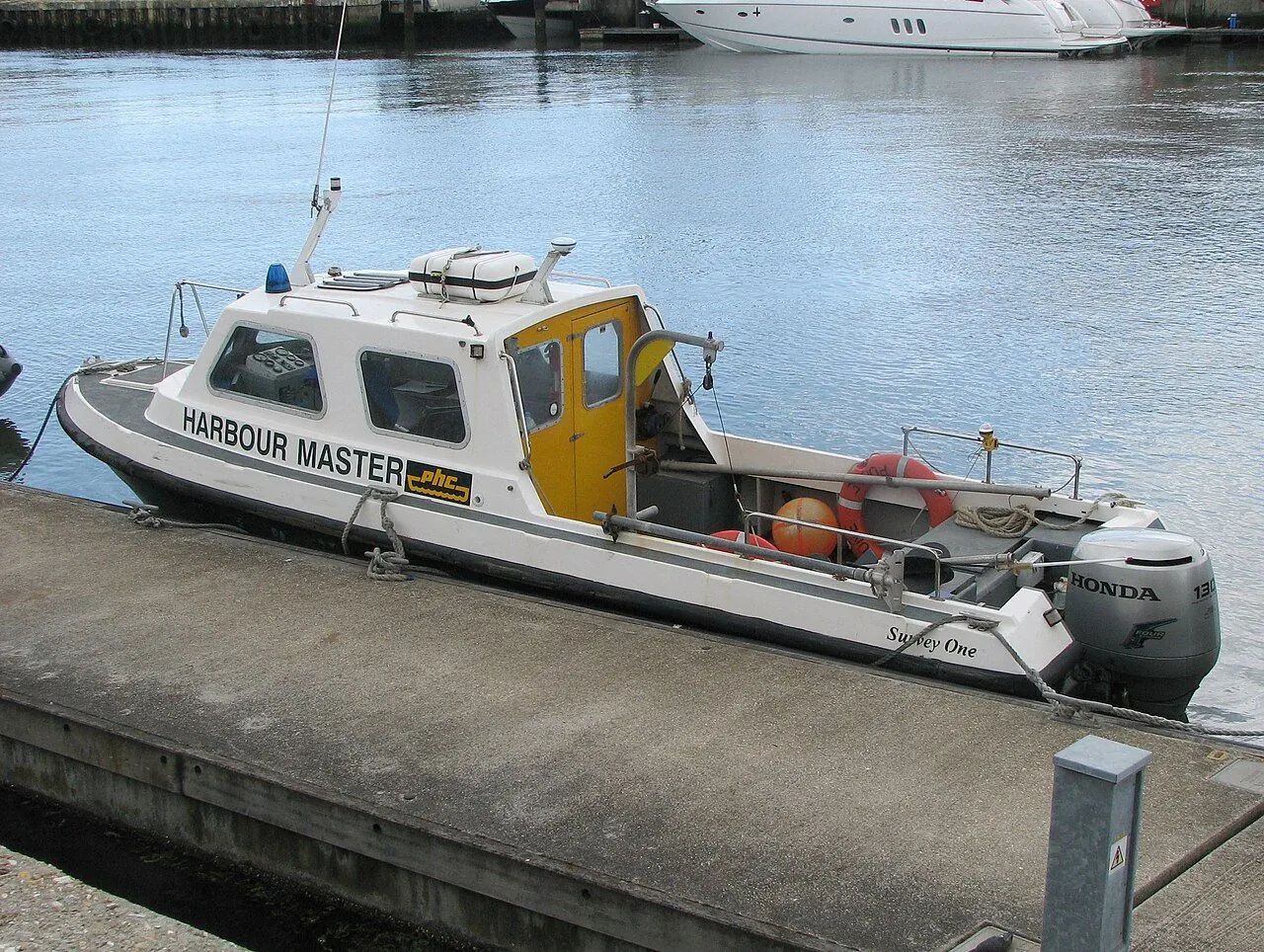 Small motorboat leaving a harbour on a calm day